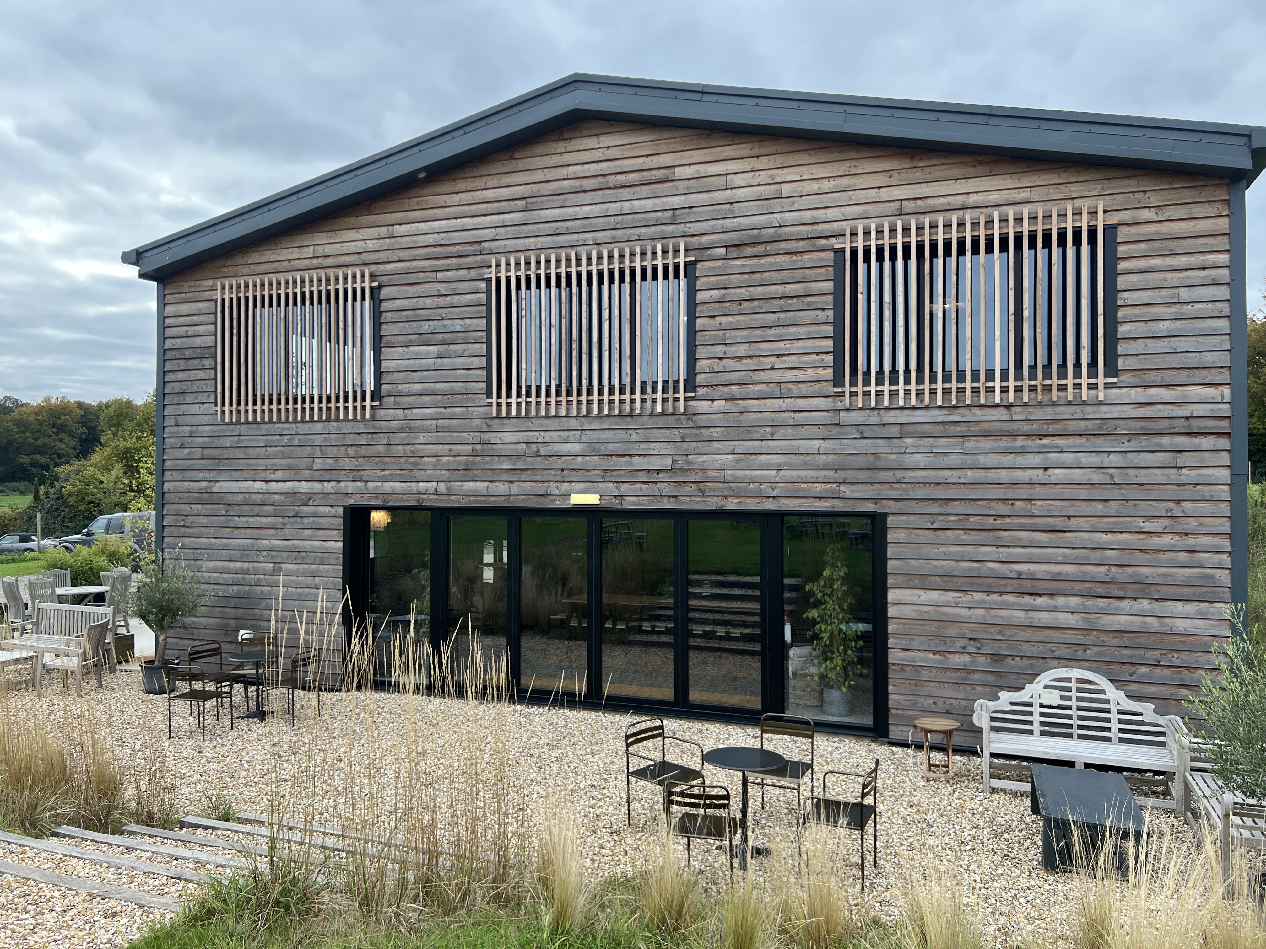 The Raimes winery building with modern timber cladding and a sheltered gravel seating area
